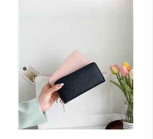 Close-up of litchi texture long zipper wallets in black and pink for women