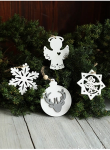 Detailed view of wood Christmas ornaments with owl and angel shapes on pine branches