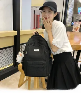 Détail du sac à dos noir matelassé avec breloque chat et plusieurs compartiments