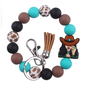 Detailed view of western cowgirl keychain with silicone beads and leather tassel charms