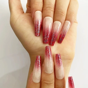 Macro detail of long coffin nails with red gradient and sparkling silver-red glitter finish