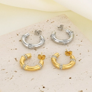 Détail de boucles d'oreilles en titane en forme de C plaquées or 18 carats et argent