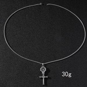 Détail du pendentif en acier inoxydable avec engrenage tête de mort et croix texturée