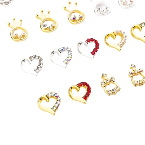 Assorted alloy heart and crown nail art charms with rhinestones and pearls on white
