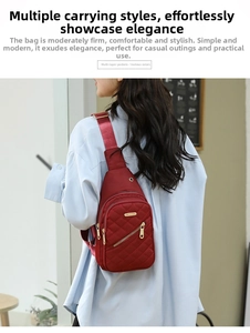 Detail of dark red quilted nylon chest bag showing multi-layer zippers on a model