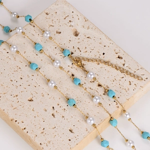 Collana a strati con turchese irregolare, perle bianche e catena dorata sottile