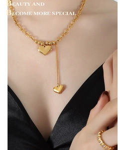 Vue détaillée du collier pendentif double coeur et de la bague zircon sur le cou du modèle