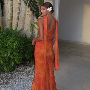 Gros plan sur le design dos nu à lacets de cette robe longue orange à imprimé fleuri