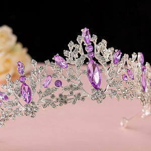 Close-up of a silver bridal crown with purple marquise crystals and sparkling rhinestones