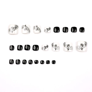 Ink leaf black and white press-on toe nails with artistic floral patterns and glossy finish