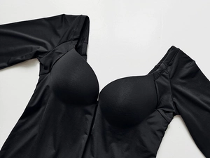 Detail of black long sleeve bodysuit with built-in pads and U-neckline in elastic fabric