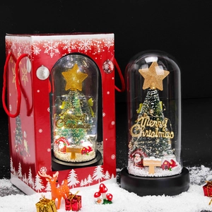 Detail of Christmas tree glass dome with red gift box and festive snow scene
