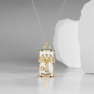 Macro shot of gold-plated rectangular Temperance tarot pendant with colorful gems