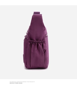 Detalle del bolso bandolera de nailon morado que muestra el bolsillo lateral para botellas