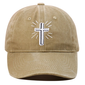 Detailed view of white cross embroidery on khaki washed cotton baseball cap