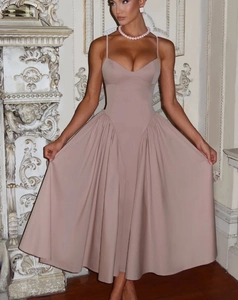 Détail de l'ourlet plissé élégant et de la taille cintrée de la robe à fines bretelles