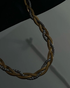 Detail of layered gold and silver braided herringbone chains with 18k plating texture