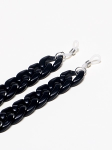 Detail of black acrylic resin eyewear chain with adjustable silicone loops and silver coil