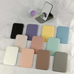Portable folding makeup mirror in multiple colors shown on a textured white surface