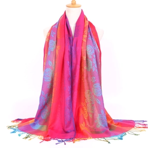 Detailed close-up of ethnic floral jacquard scarf with vibrant pink fringe and orange tassel