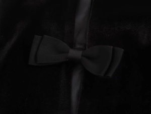 Primer plano detallado de la textura de terciopelo y el exquisito lazo negro en el vestido