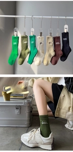 Detail of crew socks featuring outdoor camping embroidery patch in multiple earthy colors