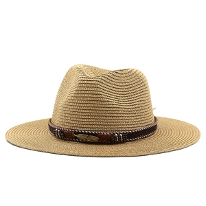 Détail du chapeau de paille avec boucle métallique plume et ruban décoratif perlé