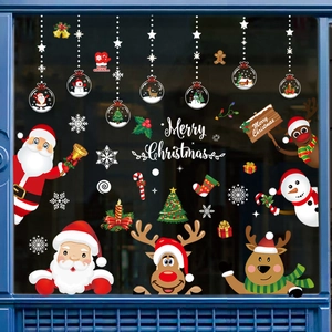 Detail of Christmas window clings showing Santa, reindeer, and snowman on blue frame glass