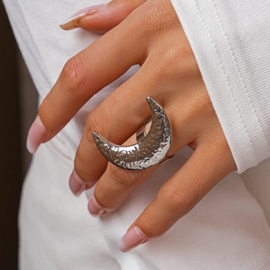 Detailed view of silver moon ring with hammered texture on a hand model