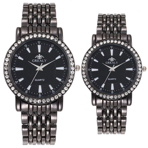 Gros plan de montres à quartz noir pour couples avec lunette strass et métal