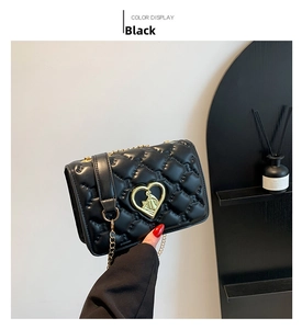 Détail du sac bandoulière matelassé noir avec fermoir cœur et chaîne dorée