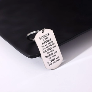 Detail of engraved stainless steel dog tag keychain with motivational message for daughter