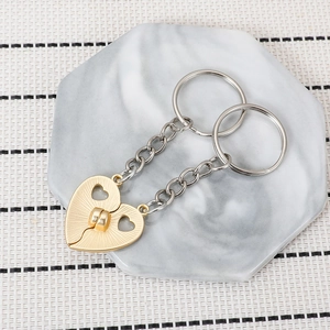 Macro shot of magnetic gold heart keychains for best friends on marble stone surface