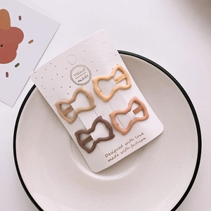 Set of four matte Earth-toned BB hair clips displayed on a card in a white ceramic dish