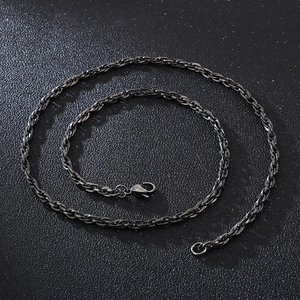 Macro shot of black twisted rope chain necklace with a lobster clasp on dark background