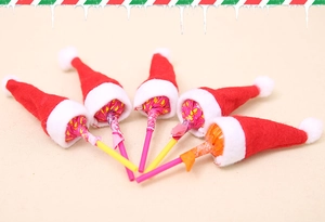 Close-up of mini red and white Christmas hats on lollipops for festive table decoration