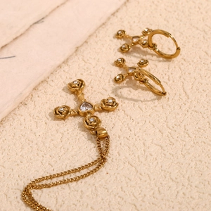 Detail of gold-plated rose cross necklace and earrings set with sparkling crystals