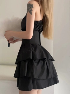 Side view detail of a black tiered ruffle mini dress with delicate spaghetti straps