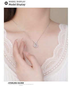 Detail of S925 sterling silver butterfly necklace with round white agate on a model