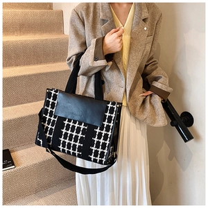Fashionable black and white houndstooth tote bag with adjustable shoulder strap