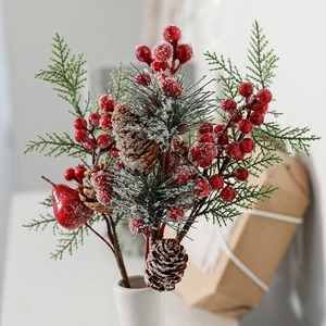 Artificial Christmas sprig with red berries, pine cones and snowy needles in white vase