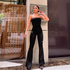 Detail of black strapless jumpsuit featuring sparkling rhinestones and flared leg style