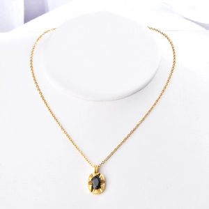 Vintage gold chain necklace featuring an irregular black zircon oval pendant on a white stand