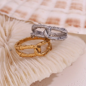 Detail of 18K gold and silver plated double-layer wrap rings on white coral background