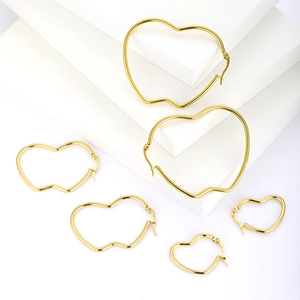 Polished gold stainless steel heart hoop earrings in three sizes on white display