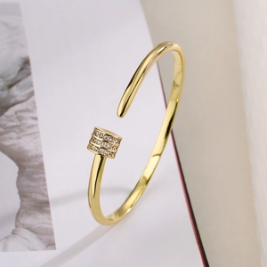 Minimalist gold-plated open bangle with three rows of white cubic zirconia cylinder design