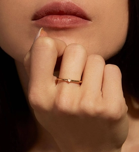 Close-up of a 925 sterling silver gold ring with a single diamond on a finger
