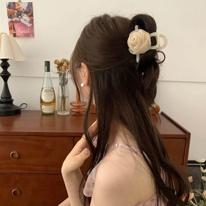 Pince à cheveux fleur de rose en organza crème sur une coiffure demi-attachée vintage