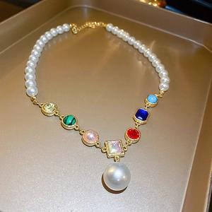 Vintage style gold pearl necklace with colorful gemstones and a large pearl drop pendant