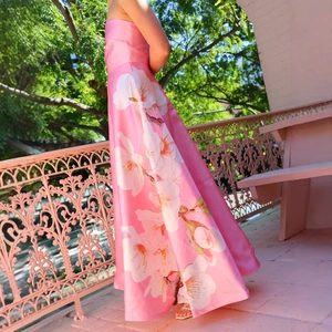 Detailansicht des rosa Maxikleids mit Blumenmuster, das die Textur und Silhouette zeigt